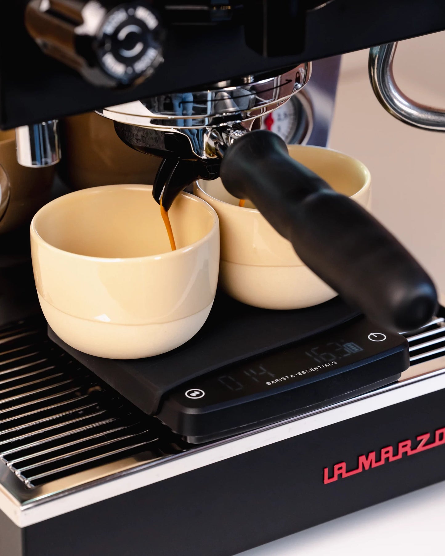 Barista-Kaffeewaage mit Timer von Barista-Essentials auf La Marzocco mit Cappuccino-Tassen