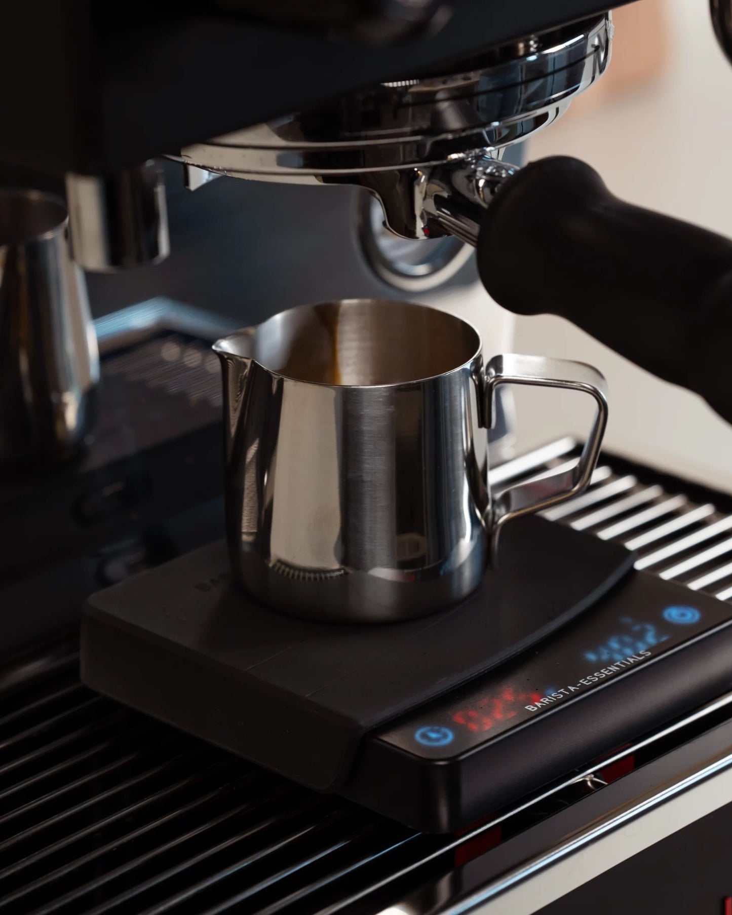 Espresso-Kännchen unter einer Maschine und auf einer Kaffeewaage