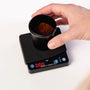 Mini-Kaffeewaage von Barista-Essentials mit Messbecher auf der Waage